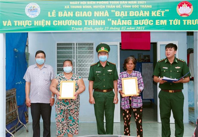 Lãnh đạo Bộ đội Biên phòng Sóc Trăng và Mặt trận Tổ quốc Việt Nam tỉnh bàn giao nhà Đại đoàn kết cho hộ nghèo tại xã Trung Bình, huyện Trần Đề. (Ảnh: Trung Hiếu/TTXVN) Sóc Trăng: Tặng nhà, học bổng cho hộ nghèo, học sinh vùng biển ảnh 1