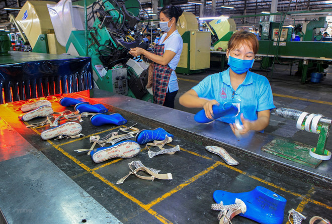 Công nhân sản xuất giày da tại Khu công nghiệp Sóng Thần, thành phố Dĩ An, tỉnh Bình Dương. (Ảnh: Chí Tưởng/TTXVN) Trên 70% công nhân quay trở lại Bình Dương làm việc sau Tết Nguyên đán ảnh 1