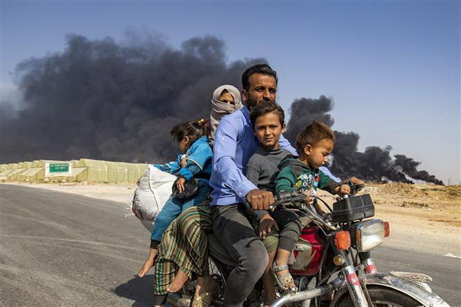 Người dân Syria sơ tán khỏi thị trấn biên giới Ras al-Ain do lo ngại xung đột leo thang ngày 16/10. (Nguồn: AFP/TTXVN) Liên hợp quốc: Gần 1.700 người Kurd ở Syria tìm cách tị nạn ở Iraq ảnh 1