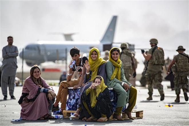 Người dân chờ lên máy bay tại sân bay quốc tế Hamid Karzai ở thủ đô Kabul để rời khỏi Afghanistan ngày 19/8/2021. (Ảnh: AFP/TTXVN) Mỹ huy động máy bay thương mại để sơ tán người ra khỏi Afghanistan ảnh 1