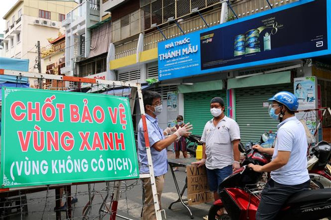 Lực lượng tình nguyện tham gia trực chốt trên đường Vườn Chuối cho biết việc lập các chốt chặn được người dân nơi đây đồng thuận rất cao do đã từng bị phong tỏa. (Ảnh: Thanh Vũ/TTXVN) Mở rộng pháo đài xanh an toàn với dịch COVID-19: Giữ vững vùng xanh ảnh 2