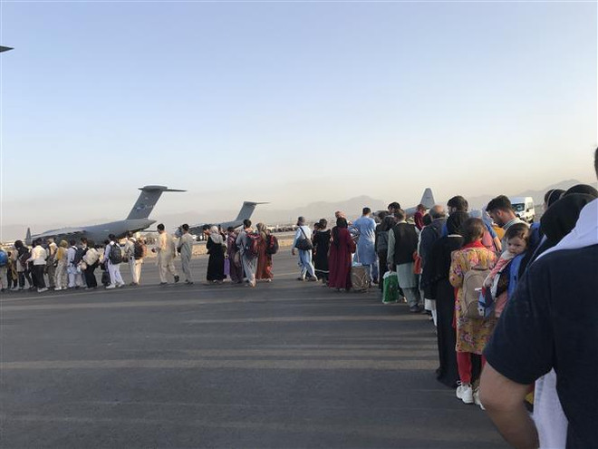 Người dân xếp hàng lên máy bay quân sự của Đức ở sân bay quốc tế Kabul (Afghanistan), để rời khỏi quốc gia Tây Nam Á, ngày 25/8/2021. (Ảnh: THX/TTXVN) Hội đồng Bảo an thông qua nghị quyết về sơ tán tại Afghanistan ảnh 1