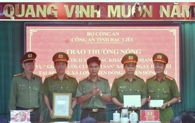 Đại tá Lê Việt Thắng, Giám đốc Công an tỉnh Bạc Liêu (đứng giữa), trao thưởng cho Ban chuyên án. (Ảnh: Hải Linh/TTXVN phát) Vụ giết người, cướp tài sản tại Bạc Liêu: Khen thưởng Ban chuyên án ảnh 1