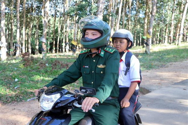 Trung úy Hoàng Như Thanh (Đội trưởng Đội vũ trang-Đồn Biên phòng Mô Rai, huyện Sa Thầy, tỉnh Kon Tum) phụ trách đưa đón và kèm cặp em A Ứng (12 tuổi) trong quá trình học tập. (Ảnh: Khoa Chương/TTXVN) Bộ đội Biên phòng đồng hành cùng trẻ em vùng biên giới Kon Tum ảnh 2