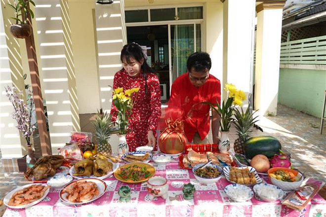 Vợ chồng chị Vinh chuẩn bị mâm cỗ trước khi cúng lễ. (Ảnh: Đỗ Sinh/TTXVN) Xuân Quý Mão 2023: Đậm đà hồn Tết ở một gia đình Thái-Việt ảnh 1
