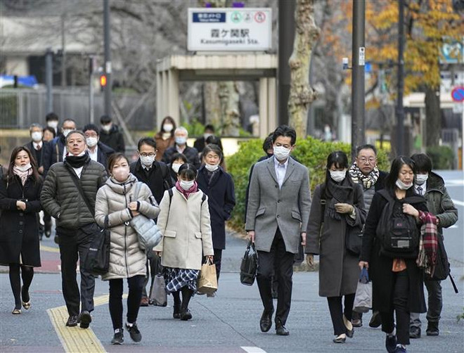 Người dân trên đường tới nơi làm việc ở Tokyo, Nhật Bản ngày 28/12/2022. (Ảnh: Kyodo/TTXVN) Nhật Bản xem xét bỏ khuyến nghị đeo khẩu trang ở trong nhà ảnh 1