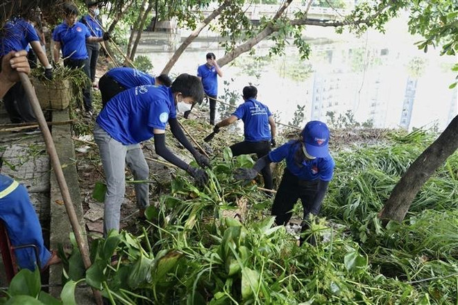 Các tình nguyện viên tham gia dọn dẹp kênh rạch tại lễ ra quân. (Ảnh: Hồng Giang/TTXVN) Phát huy sức trẻ vì môi trường xanh trong chiến dịch tình nguyện Hè ảnh 1