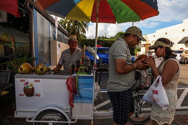 Người dân uống nước giải nhiệt tại Miami, Florida, Mỹ, ngày 26/6/2023. (Ảnh: AFP/TTXVN) Nhiều khu vực trên thế giới đối mặt với nắng nóng khắc nghiệt ảnh 1