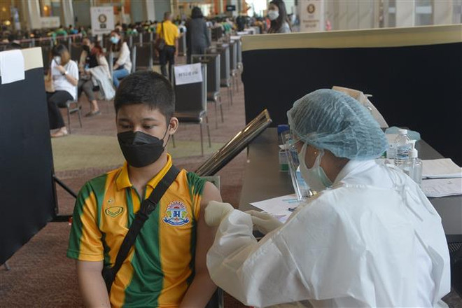 Nhân viên y tế tiêm vaccine ngừa COVID-19 cho trẻ em tại Bangkok, Thái Lan, ngày 19/10/2021. (Ảnh: THX/TTXVN) Chuyên gia gợi ý chỉ tiêm một mũi vaccine phòng COVID-19 cho trẻ em ảnh 1