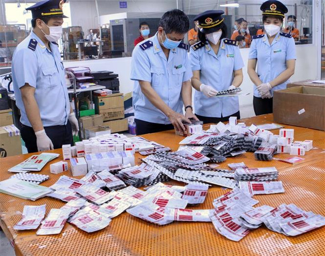 Cục Hải quan thành phố Hà Nội phát hiện, bắt giữ nhiều lô hàng test nhanh và các loại thuốc được cho là thuốc điều trị bệnh COVID-19. (Ảnh: TTXVN phát) Quản lý thị trường mở đợt cao điểm chống buôn lậu, gian lận thương mại ảnh 2
