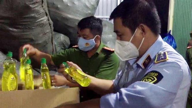 Tổ liên ngành chống buôn lậu tỉnh An Giang phát hiện hàng ngàn chai nước rửa chén nhái nhãn hiệu nổi tiếng tại cơ sở kinh doanh Lâm Thị Y. (Ảnh: TTXVN phát) Quản lý thị trường mở đợt cao điểm chống buôn lậu, gian lận thương mại ảnh 1
