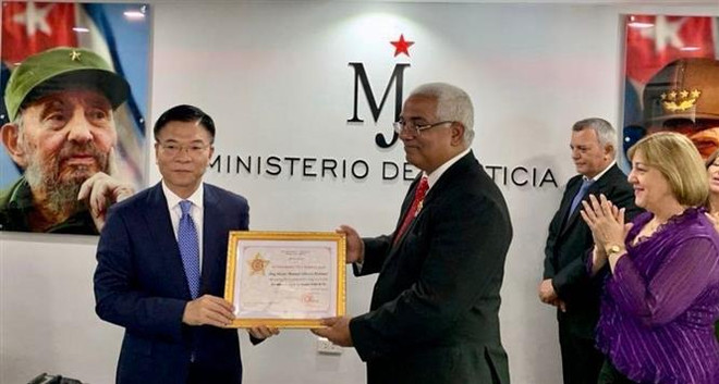 Bộ trưởng Lê Thành Long trao tặng Kỷ niệm chương "Vì sự nghiệp tư pháp” cho Bộ trưởng Tư pháp Cuba Oscar Manuel Silvera Martínez. (Ảnh: Mai Phương/TTXVN) Việt Nam và Cuba tăng cường hợp tác về lĩnh vực tư pháp ảnh 2