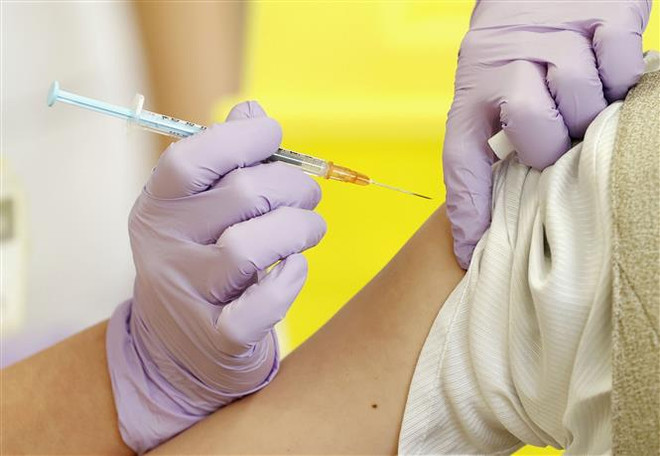 Nhân viên y tế tiêm vaccine phòng COVID-19 cho người dân tại Yatsushiro, tỉnh Kumamoto, Nhật Bản. (Ảnh: Kyodo/ TTXVN) Vaccine COVID-19 công nghệ truyền thống giúp giảm thiểu ca bệnh nặng ảnh 1