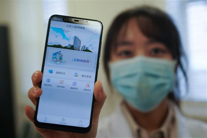 Nhân viên y tế bệnh viện ở Nam Kinh, tỉnh Giang Tô (Trung Quốc) giới thiệu trang mạng tư vấn trực tuyến sơ bộ về virus corona chủng mới (COVID-19) hỗ trợ người dân phòng ngừa và ngăn chặn khả năng lây lan của dịch bệnh, ngày 7/2/2020. (Nguồn: THX/TTXVN) Tin giả có thể làm dịch bệnh COVID-19 diễn biến tệ hại hơn ảnh 1