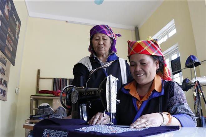 Những sản phẩm thổ cẩm độc đáo đang được hoàn thiện dưới đường may khéo léo của phụ nữ Mông. (Ảnh: Việt Dũng/TTXVN) Độc đáo nghề dệt thổ cẩm của đồng bào Mông ở huyện Mù Cang Chải ảnh 1