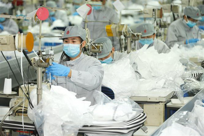 Công nhân làm việc tại một nhà máy sản xuất khẩu trang ở Sơn Đông, Trung Quốc ngày 12/2/2020. (Nguồn: THX/TTXVN) Chuyên gia WHO, Trung Quốc thị sát việc phòng chống dịch COVID-19 ảnh 1