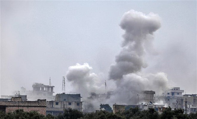 Khói bốc lên sau một cuộc oanh kích do các lực lượng Chính phủ Syria và đồng minh tiến hành tại thị trấn Sarmin, tỉnh Idlib ngày 4/2/2020. (Nguồn: AFP/TTXVN) Phiến quân Syria bắn hạ máy bay trực thăng của chính quyền ảnh 1