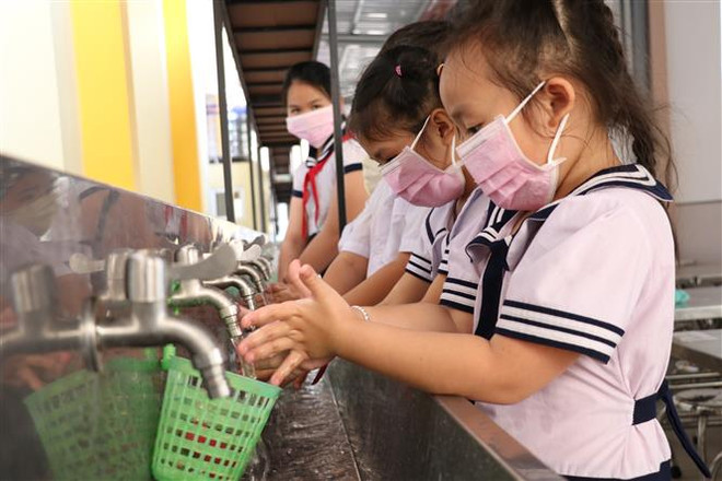 Học sinh tại một trường tiểu học trên địa bàn tỉnh Bến Tre thường xuyên rửa tay để phòng tránh bệnh. (Ảnh: Huỳnh Phúc Hậu/TTXVN) Dịch bệnh COVID-19: Hãy tăng sức đề kháng, đừng lạm dụng khẩu trang ảnh 2