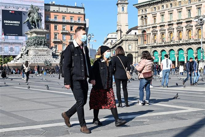 Khách thăm quan đeo khẩu trang phòng dịch COVID-19 tại quảng trường del Duomo, Milan, Italy, ngày 24/2/2020. (Nguồn: AFP/TTXVN) Miền Nam Italy có trường hợp đầu tiên dương tính với SARS-CoV-2 ảnh 1