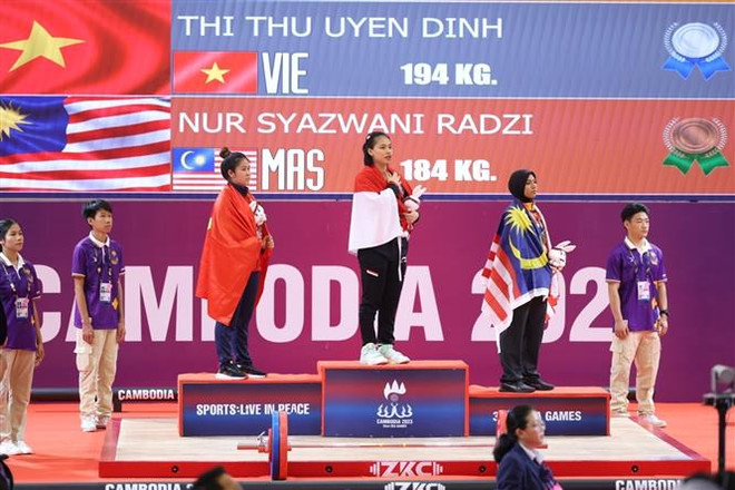 Ngày 15/5, tại Khu phức hợp sân Olympic (Phnom Penh, Campuchia) tiếp tục diễn ra các nội dung thi đấu môn Cử tạ tại SEA Games 32. Vận động viên Ramadani của Indonesia giành giành huy chương Vàng. Vận động viên Đinh Thị Thu Uyên giành huy chương Bạc với thành tích 194kg. (Ảnh: Minh Quyết/TTXVN) Đoàn thể thao Indonesia hoàn thành chỉ tiêu huy chương Vàng ảnh 1