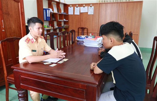 Lực lượng chức năng làm việc với hai học sinh V.H.H.A và P.V.T.V. (Ảnh: Đậu Tất Thành/TTXVN) Xử lý nghiêm học sinh đi xe máy 'bốc đầu' khoe lên mạng xã hội ảnh 1