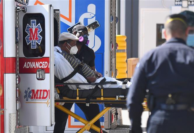 Nhân viên y tế chuyển bệnh nhân COVID-19 tới trung tâm y tế ở New York, Mỹ. (Ảnh: AFP/TTXVN) Nghiên cứu của Mỹ xác định các triệu chứng chính của COVID kéo dài ảnh 1