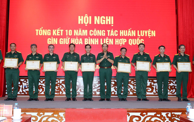 Thượng tướng Phùng Sĩ Tấn, Phó Tổng Tham mưu trưởng Quân đội Nhân dân Việt Nam, Tổ phó Tổ công tác liên ngành, Phó trưởng Ban Chỉ đạo Bộ Quốc phòng về tham gia gìn giữ hòa bình Liên hợp quốc trao Bằng khen của Bộ trưởng Bộ Quốc phòng cho các cá nhân. (Ảnh: Trọng Đức/TTXVN) ttxvn_gin_giu_hoa_binh_2.jpg