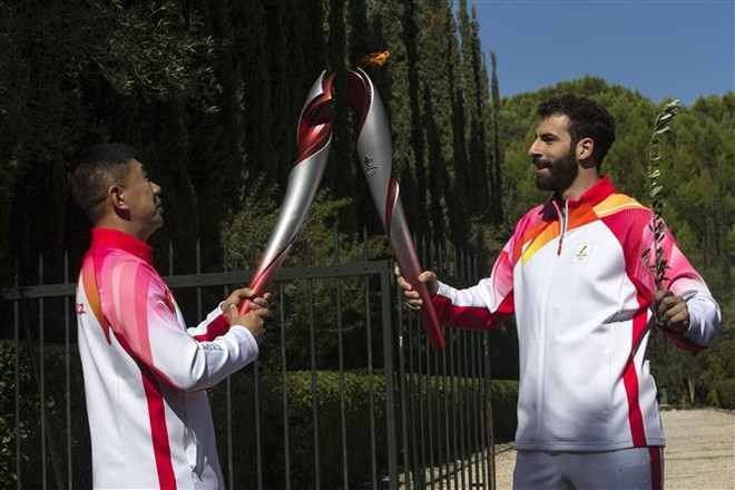 Vận động viên trượt tuyết người Hy Lạp Ioannis Antoniou (phải) truyền ngọn đuốc Olympic của Thế vận hội mùa Đông Bắc Kinh 2022 cho cựu vận động viên trượt băng tốc độ quãng đường ngắn người Trung Quốc Li Jiajun, ở Olympia (Hy Lạp), ngày 18/10/2021. (Ảnh: THX/TTXVN) Hy Lạp trao ngọn đuốc Olympic Bắc Kinh 2022 cho Trung Quốc ảnh 1