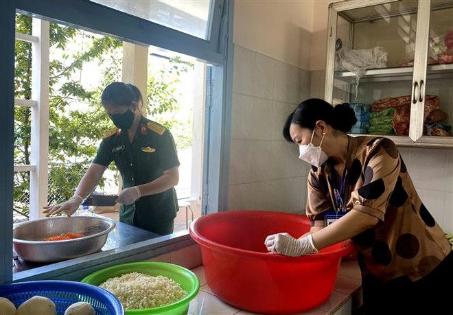 Bếp ăn nghĩa tình của Hội Liên hiệp Phụ nữ thành phố Vĩnh Long đồng hành hỗ trợ lực lượng tuyến đầu chống dịch. (Ảnh: Lê Thúy Hằng/TTXVN) Những 'bóng hồng' trên phòng tuyến chống dịch: Hậu phương thầm lặng ảnh 1