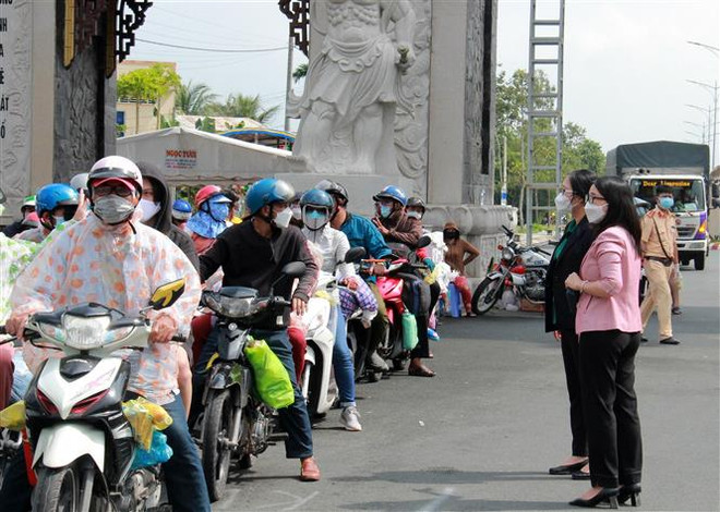 Phó Giám đốc Sở Y tế tỉnh Vĩnh Long Hồ Thị Thu Hằng đón và động viên người dân từ Thành phố Hồ Chí Minh trở về địa phương. (Ảnh: Lê Thúy Hằng/TTXVN) Những 'bóng hồng' trên phòng tuyến chống dịch: Hậu phương thầm lặng ảnh 2