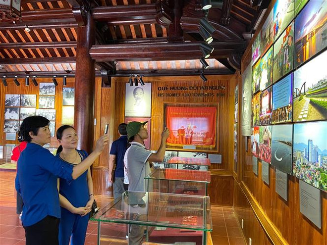 Trong ảnh: Du khách tham quan và nghe thuyết minh về những kỷ vật về Bác Hồ tại Nhà trưng bày bổ sung tại Khu di tích quốc gia đặc biệt Kim Liên. (Ảnh: Bích Huệ/TTXVN) Nơi lưu giữ và làm sống lại những kỷ vật của Chủ tịch Hồ Chí Minh ảnh 1