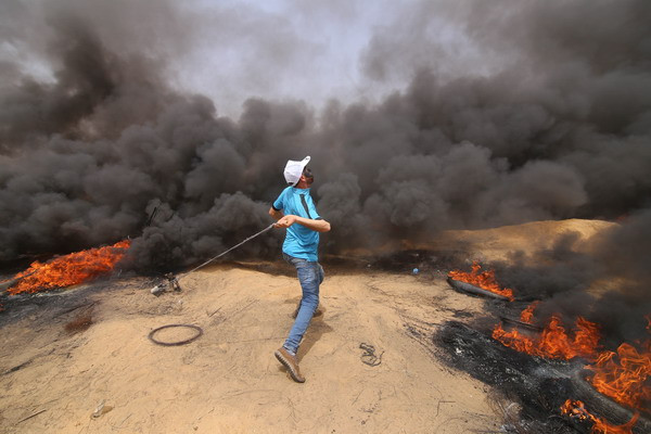 Người biểu tình Palestine xung đột với binh sỹ Israel ở Dải Gaza ngày 20/4. (Nguồn: THX/TTXVN) Quân đội Israel nổ súng ở Dải Gaza, gần 200 người bị thương ảnh 1