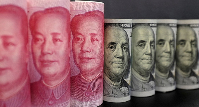 Đồng tiền giấy 100 nhân dân tệ (trái) và đồng USD ở Bắc Kinh. (Nguồn: Reuters/TTXVN) Bộ Ngoại giao Trung Quốc chỉ trích tuyên bố của Mỹ về tiền tệ ảnh 1
