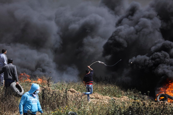 Người biểu tình Palestine đốt lốp xe và ném đá vào binh sỹ Israel trong cuộc biểu tình dọc biên giới giữa khu vực phía Đông Dải Gaza và Israel. (Nguồn: THX/TTXVN) Bạo lực bùng phát trở lại suốt dọc biên giới Israel-Gaza ảnh 1