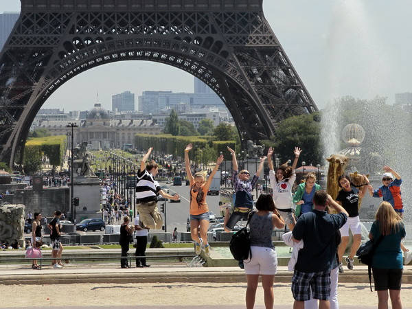 Khách du lịch bên Tháp Eiffel ở Paris (Pháp). (Nguồn: AFP/TTXVN) Paris tráng lệ vẫn là điểm đến du lịch hàng đầu thế giới ảnh 1