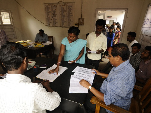 Nhân viên bầu cử kiểm tra danh sách cử tri tại một địa điểm bỏ phiếu ở Dekhijuli, bang Assam ngày 7/4. (Nguồn: AFP/TTXVN) Ấn Độ tiến hành giai đoạn cuối của bầu cử Hạ nghị viện ảnh 1