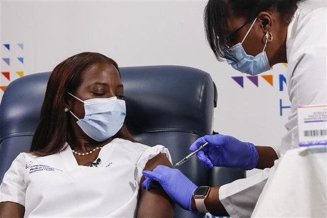 Nhân viên y tế tiêm vaccine ngừa COVID-19 cho người dân tại New York, Mỹ . (Ảnh: AFP/TTXVN) WHO đạt thêm 3 thỏa thuận chia sẻ sáng chế công nghệ vaccine COVID-19 ảnh 1