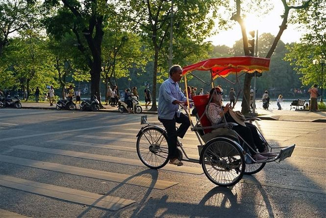 Du khách trải nghiệm du lịch quanh hồ Hoàn Kiếm bằng xích lô. (Ảnh: Khánh Hòa/TTXVN) Dịch vụ lưu trú của Hà Nội phục hồi tích cực nhờ du lịch khởi sắc ảnh 1