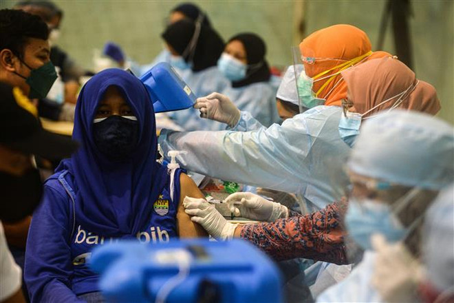 Người dân tiêm vaccine ngừa COVID-19 tại Tangerang, Indonesia, ngày 17/7/2021. (Ảnh: THX/TXVN) Hơn 4,1 triệu người trên thế giới đã tử vong vì dịch COVID-19 ảnh 1