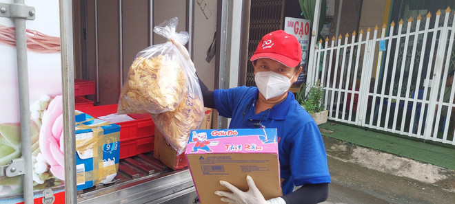 Nhà báo Phạm Đỗ Minh Trung mang hàng hóa đến các khu dân cư, khu vực cách ly tập trung. (Ảnh: Ngọc Thiện/TTXVN) Nhà báo hết lòng vì bệnh nhân nghèo, người gặp khó khăn giữa mùa dịch ảnh 1