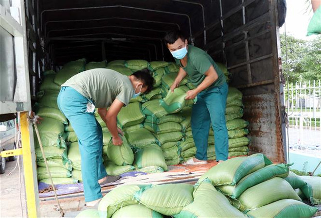 Bốc xếp hàng hóa do chính quyền, nhân dân Quảng Trị tặng lên các xe vận tải nhỏ chuyển đến các khu tập trung, khu cách ly tại các quận, huyện của Thành phố. (Ảnh: TTXVN) Chỉ nên thực hiện '3 tại chỗ' ở nơi dịch bệnh vẫn kiểm soát được ảnh 2