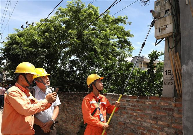 Kiểm tra quy trình ghi chỉ số côngtơ tại Công ty Điện lực Mê Linh. (Ảnh: Ngọc Hà/TTXVN) Phương án bán điện 1 giá: Tính toán để hài hòa lợi ích ảnh 1