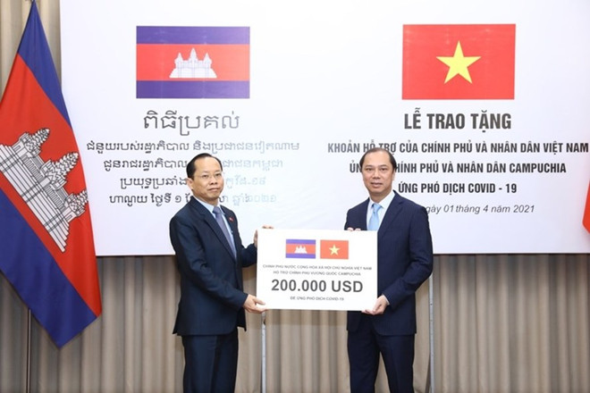 Thứ trưởng Ngoại giao Nguyễn Quốc Dũng trao tượng trưng cho Đại sứ Campuchia tại Việt Nam Chay Navuth khoản hỗ trợ 200.000 USD của Chính phủ và nhân dân Việt Nam. (Nguồn: Bộ Ngoại giao) Trao khoản hỗ trợ giúp Campuchia ứng phó với dịch COVID-19 ảnh 1