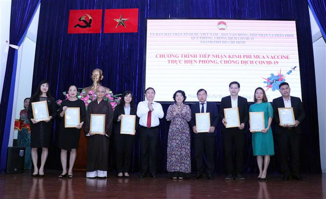 Bà Tô Thị Bích Châu, Chủ tịch Ủy ban Mặt trận Tổ quốc Việt Nam Thành phố Hồ Chí Minh và ông Dương Anh Đức, Phó Chủ tịch Ủy ban nhân dân Thành phố gửi Thư cảm ơn các đơn vị, cá nhân ủng hộ kinh phí phục vụ công tác mua vaccine phòng, chống COVID-19. (Ảnh: Xuân Khu/TTXVN) TP.HCM tiếp nhận hơn 200 tỷ đồng ủng hộ mua vaccine phòng COVID-19 ảnh 1