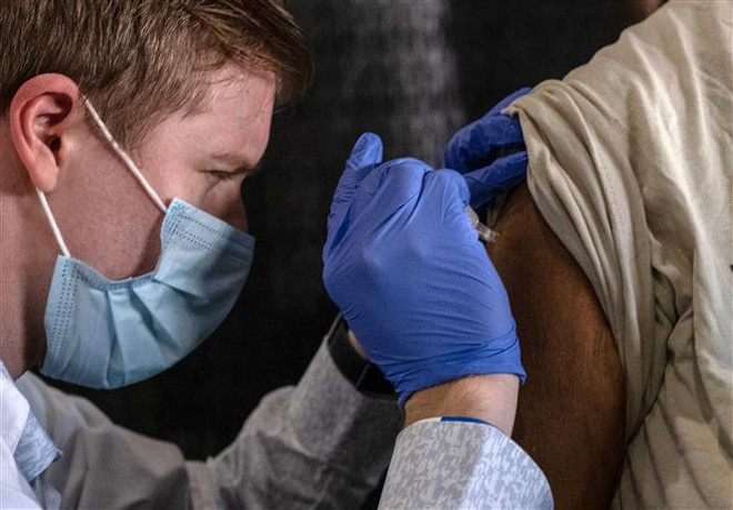 Nhân viên y tế tiêm vaccine ngừa COVID-19 cho người dân tại Detroit, Michigan, Mỹ. (Ảnh: AFP/TTXVN) Số ca tử vong ở châu Mỹ lần đầu giảm kể từ khi xuất hiện Omicron ảnh 1