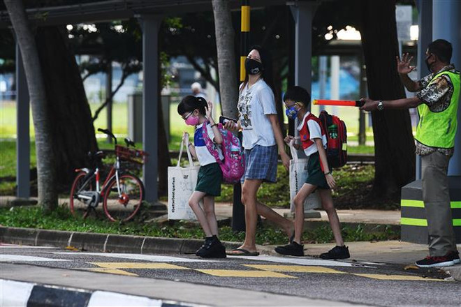 Người dân đeo khẩu trang phòng lây nhiễm COVID-19 tại Singapore ngày 2/6/2020. (Nguồn: THX/TTXVN) Dịch COVID-19: Singapore mở cửa giai đoạn hai từ cuối tuần này ảnh 1