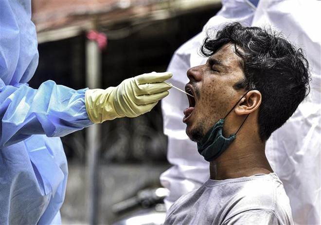 Nhân viên y tế lấy mẫu xét nghiệm COVID-19 cho người dân tại New Delhi, Ấn Độ ngày 6/6/2020. (Nguồn: THX/TTXVN) Ấn Độ: Tỷ lệ xét nghiệm dương tính với virus SARS-CoV-2 tăng mạnh ảnh 1
