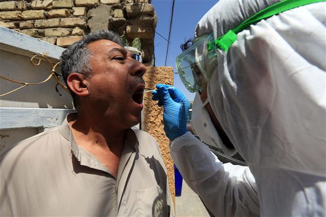 Nhân viên y tế lẫy mẫu xét nghiệm COVID-19 tại Baghdad, Iraq. (Nguồn: THX/TTXVN) Cần hơn 31 tỷ USD để phát triển bộ xét nghiệm, vắcxin, thuốc COVID-19 ảnh 1