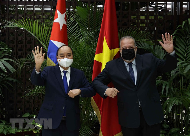 Chủ tịch nước Nguyễn Xuân Phúc và Thủ tướng Cộng hòa Cuba Manuel Marrero Cruz vẫy tay chào. (Ảnh: Thống Nhất/TTXVN) Chủ tịch nước Nguyễn Xuân Phúc hội kiến Thủ tướng Cuba ảnh 1