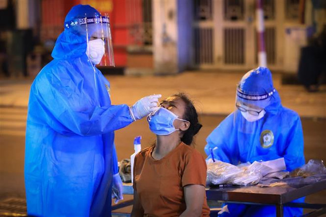 Lấy mẫu xét nghiệm COVID-19. (Ảnh: Thành Đạt/TTXVN) Hà Nội: Thiết lập vùng cách ly y tế tại phường Thổ Quan ảnh 1
